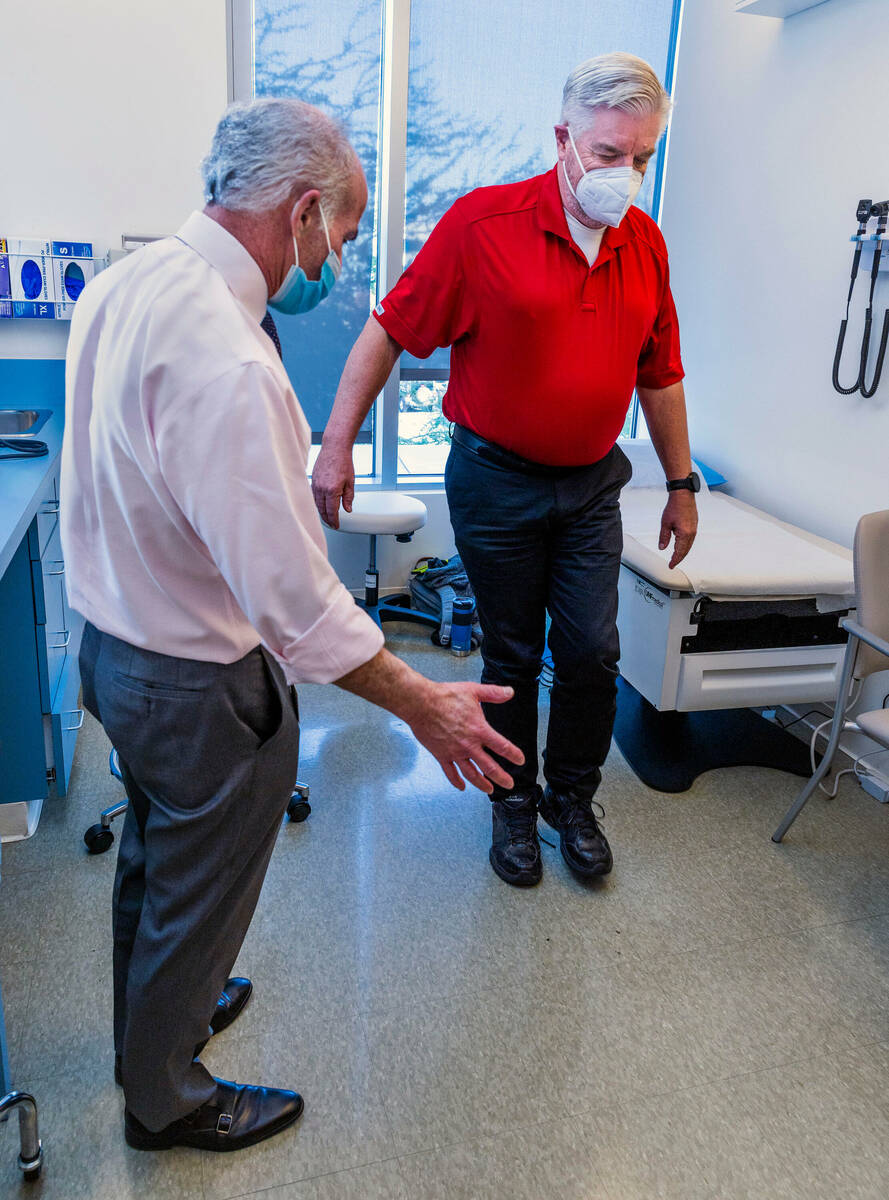 Dr. Charles Bernick, left, checks the balance of clinical trial participant Bob Lathrop before ...