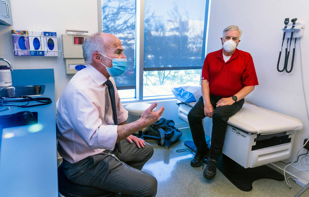 Dr. Charles Bernick talks with clinical trial participant Bob Lathrop before he receives his ne ...