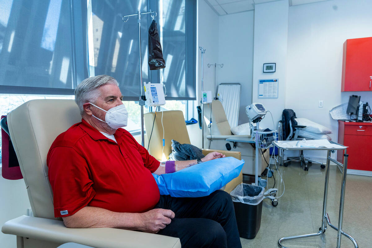 Clinical trial participant Bob Lathrop meets with Dr. Charles Bernick and gets his infusion of ...