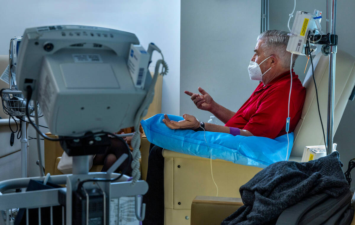 Clinical trial participant Bob Lathrop chats while he receives his next infusion of the Alzheim ...