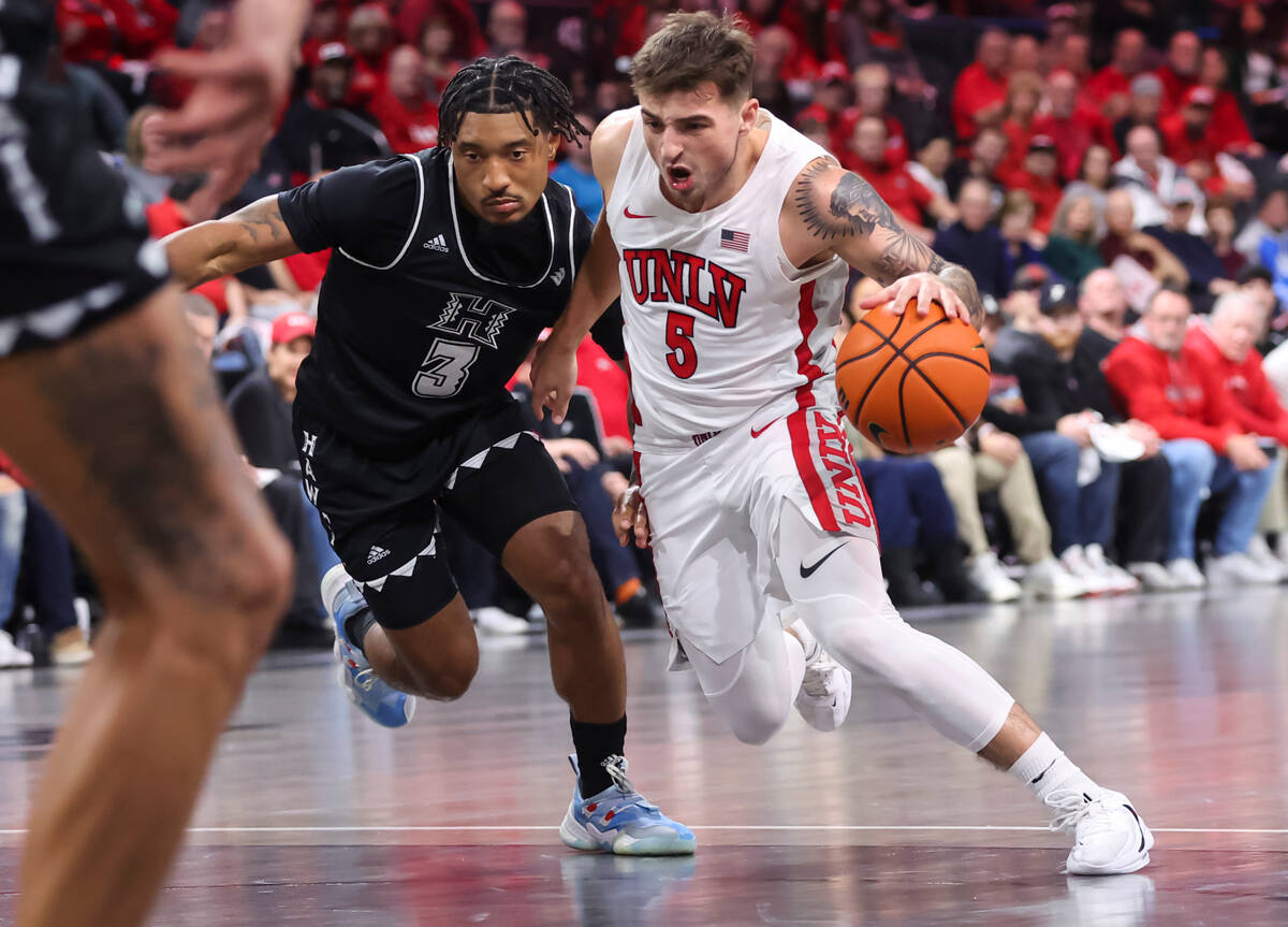 UNLV Rebels guard Jordan McCabe (5) drives the ball under pressure from Hawaii Warriors guard J ...