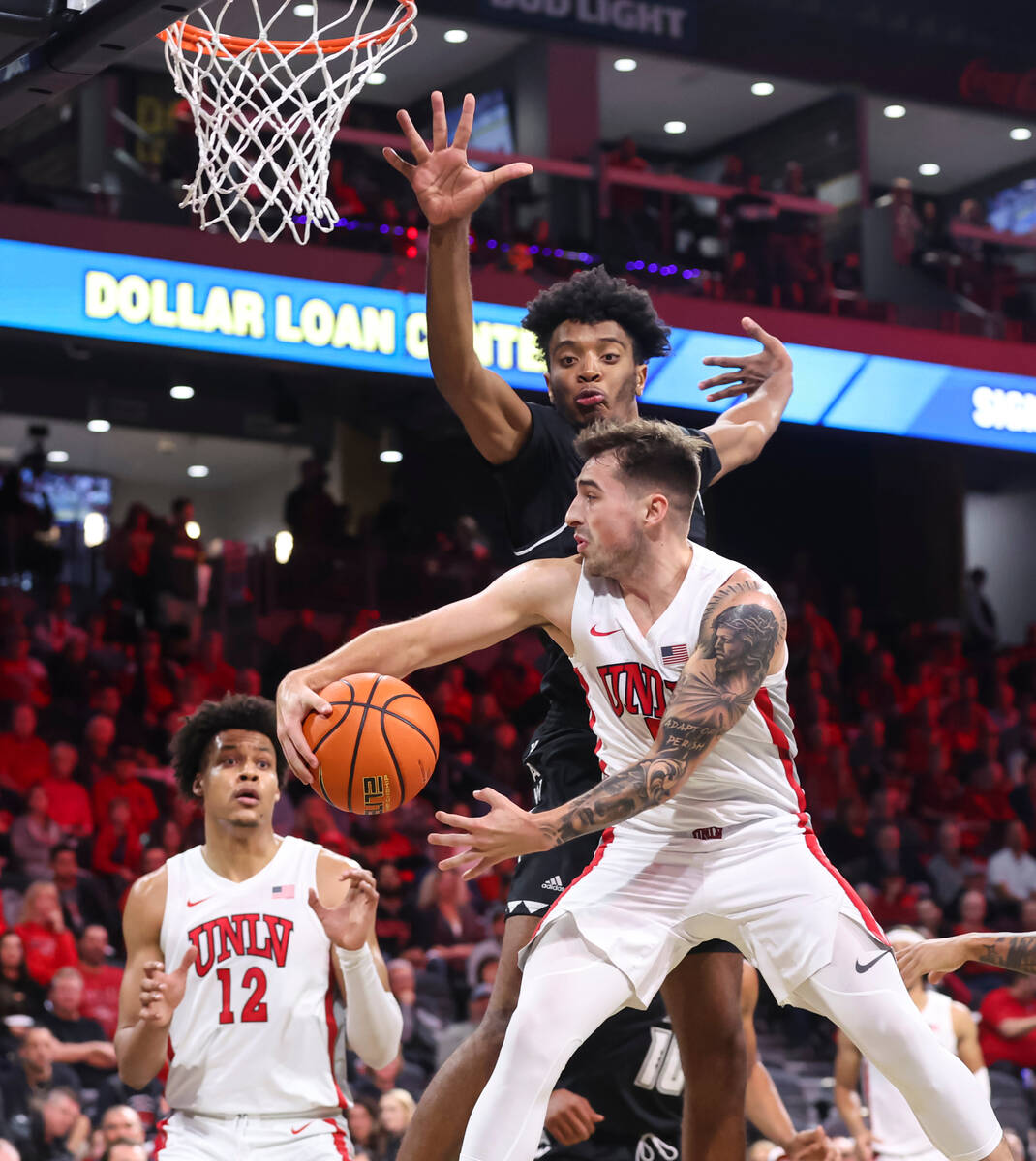 UNLV Rebels guard Jordan McCabe (5) passes the ball under pressure from Hawaii Warriors forward ...