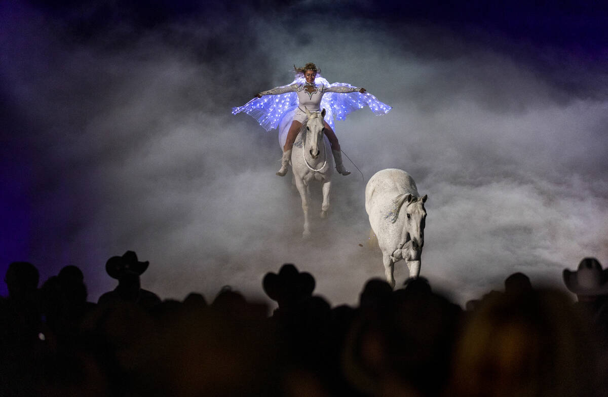 Trik dan pembalap Romawi Jessica Fowlkes mengikuti seekor kuda melintasi cincin yang dipenuhi asap selama kenangan ...