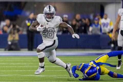 Raiders running back Josh Jacobs (28) escaped being tackled by Los Angeles Rams cornerback Cobi ...