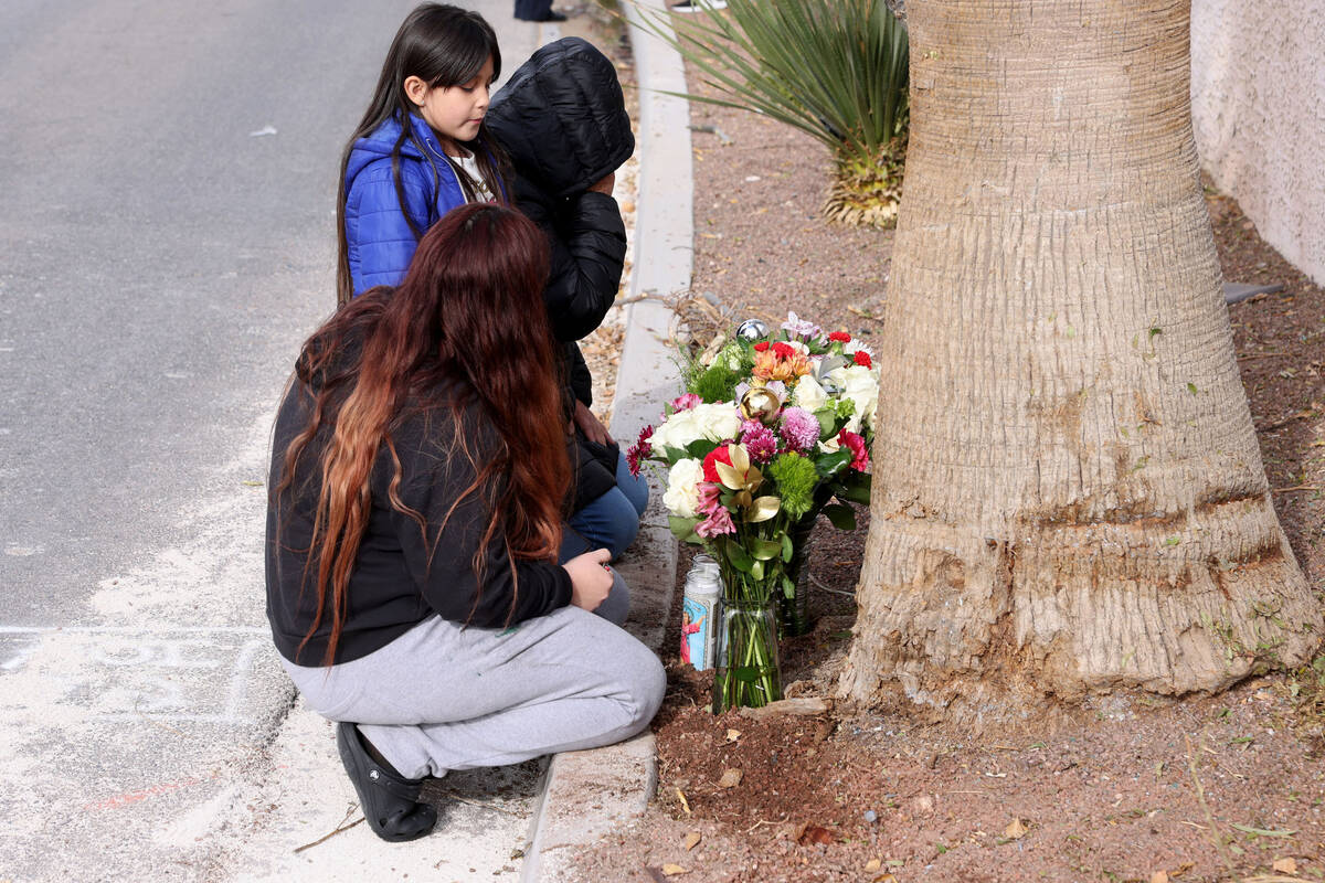 Rosario Garcia, foreground, her daughter Marissa, 6, and mother Leticia place flowers and candl ...