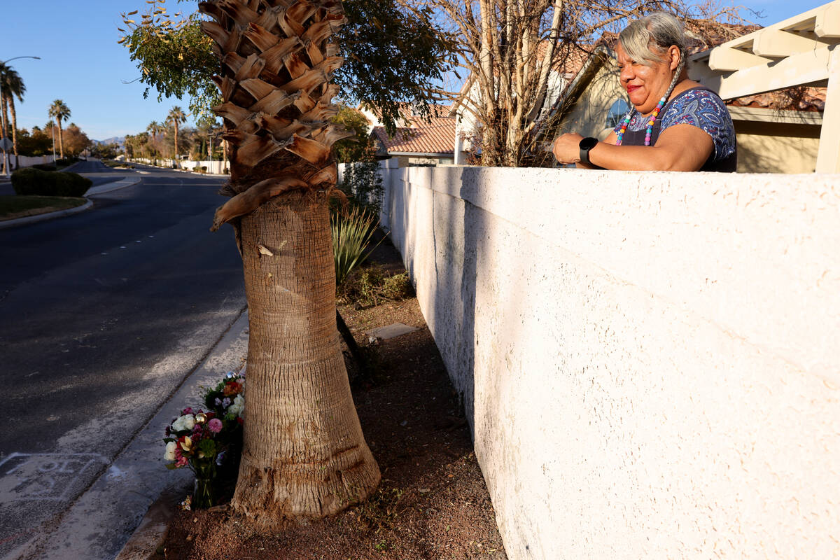 Tracey Herring looks over her backyard wall at a makeshift memorial at the site of a deadly cra ...