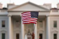 FILE - A flag is waved during an immigration rally outside the White House, in Washington, Sept ...