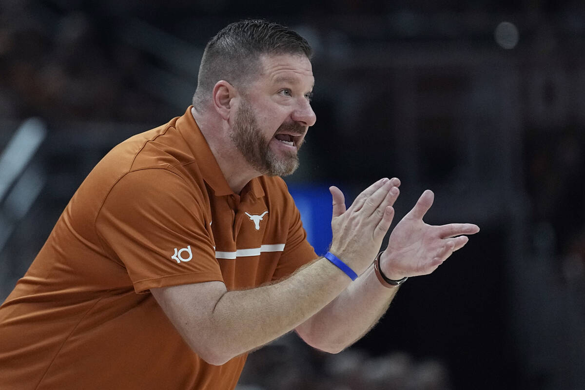 Texas head coach Chris Beard talks to his players during the first half of an NCAA college bask ...