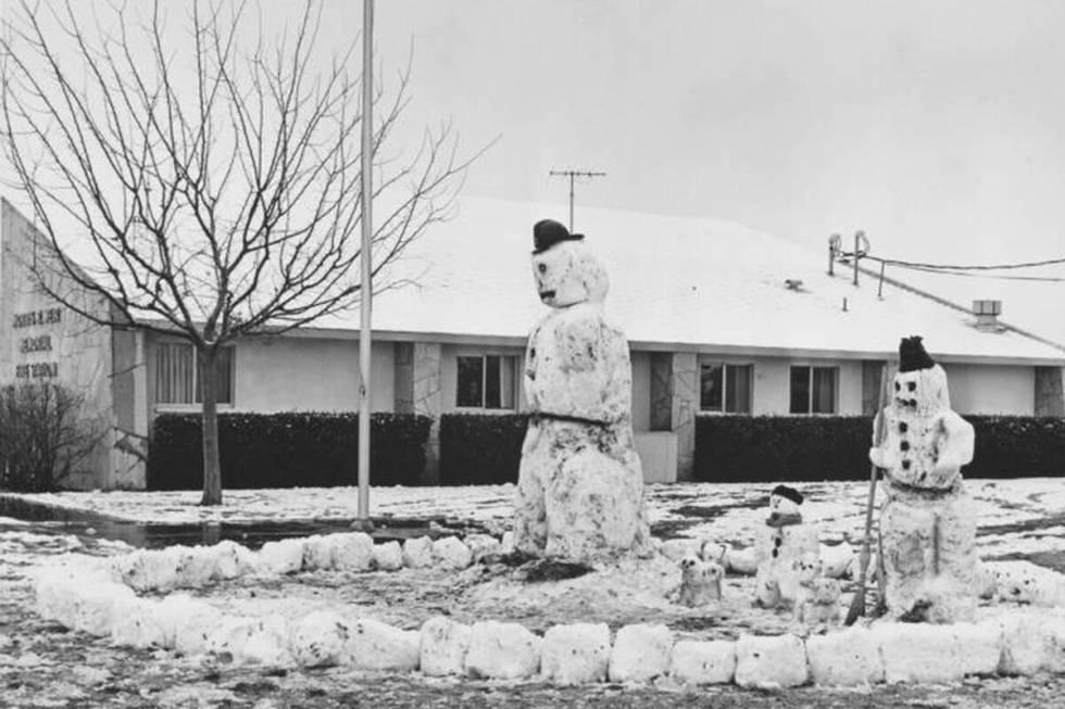 Satu keluarga manusia salju berdiri di halaman di Stasiun Pemadam Kebakaran Memorial Morris R. Weir di North Las...