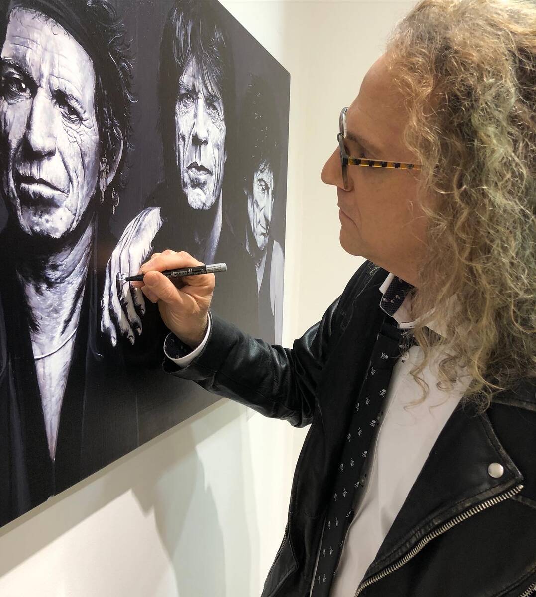 Rock drummer and artist John Douglas touches up his Rolling Stones painting at Animazing Galler ...