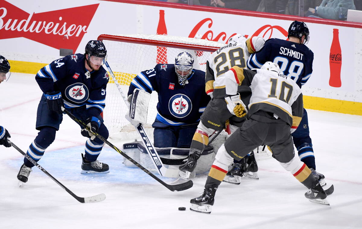 Vegas Golden Knights' Mark Stone (61) celebrates his goal against the Winnipeg Jets with Chandl ...