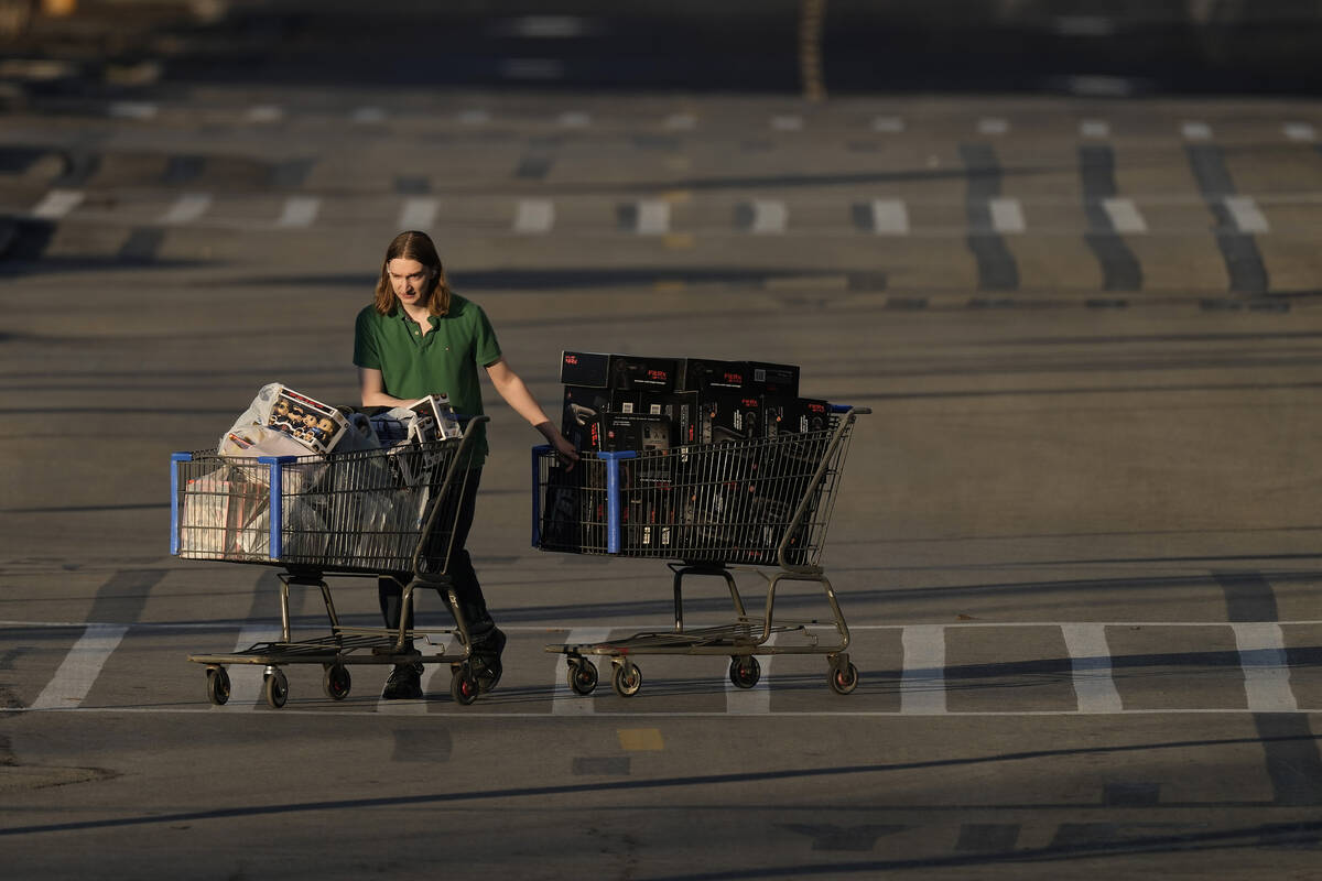FILE - A shopper leaves a Walmart after attending a Black Friday sale Friday, Nov. 25, 2022, in ...