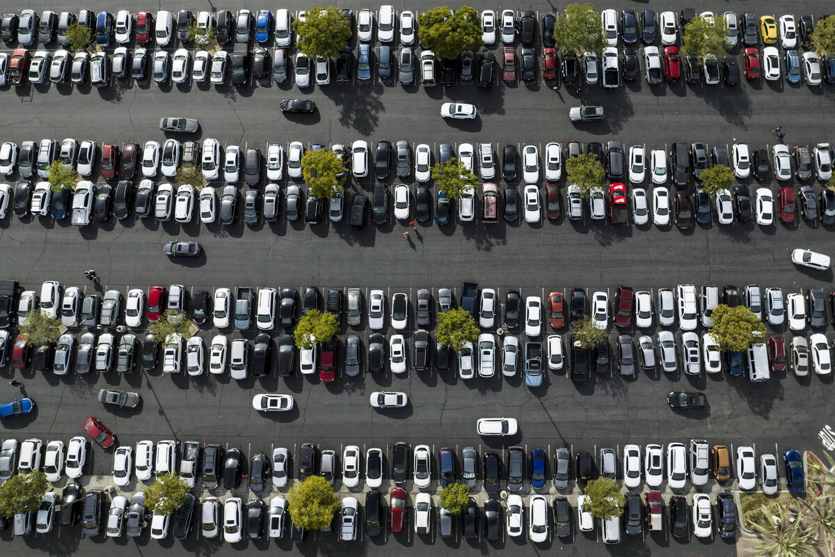 FILE - In this photo taken by a drone, motorists look for an open space to park in the parking ...