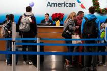 FILE - Travelers check in at an airline ticket counter at O'Hare International Airport in Chica ...