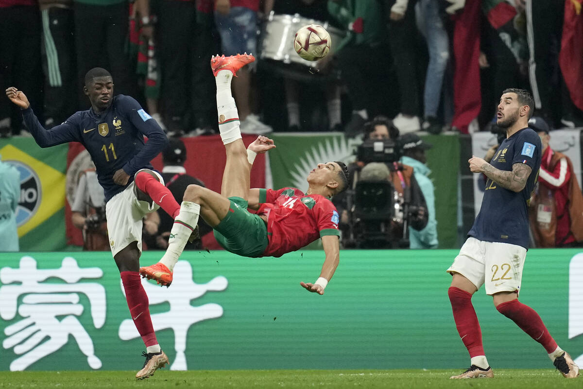 Morocco's Jawad El Yamiq, center, attempts a shot at goal during the World Cup semifinal soccer ...