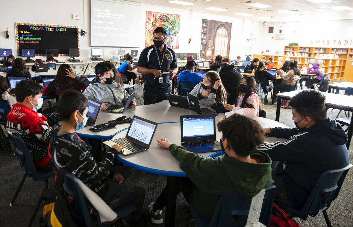 Cristian Calata, center, a substitute teacher at Bailey Middle School, works with three classes ...