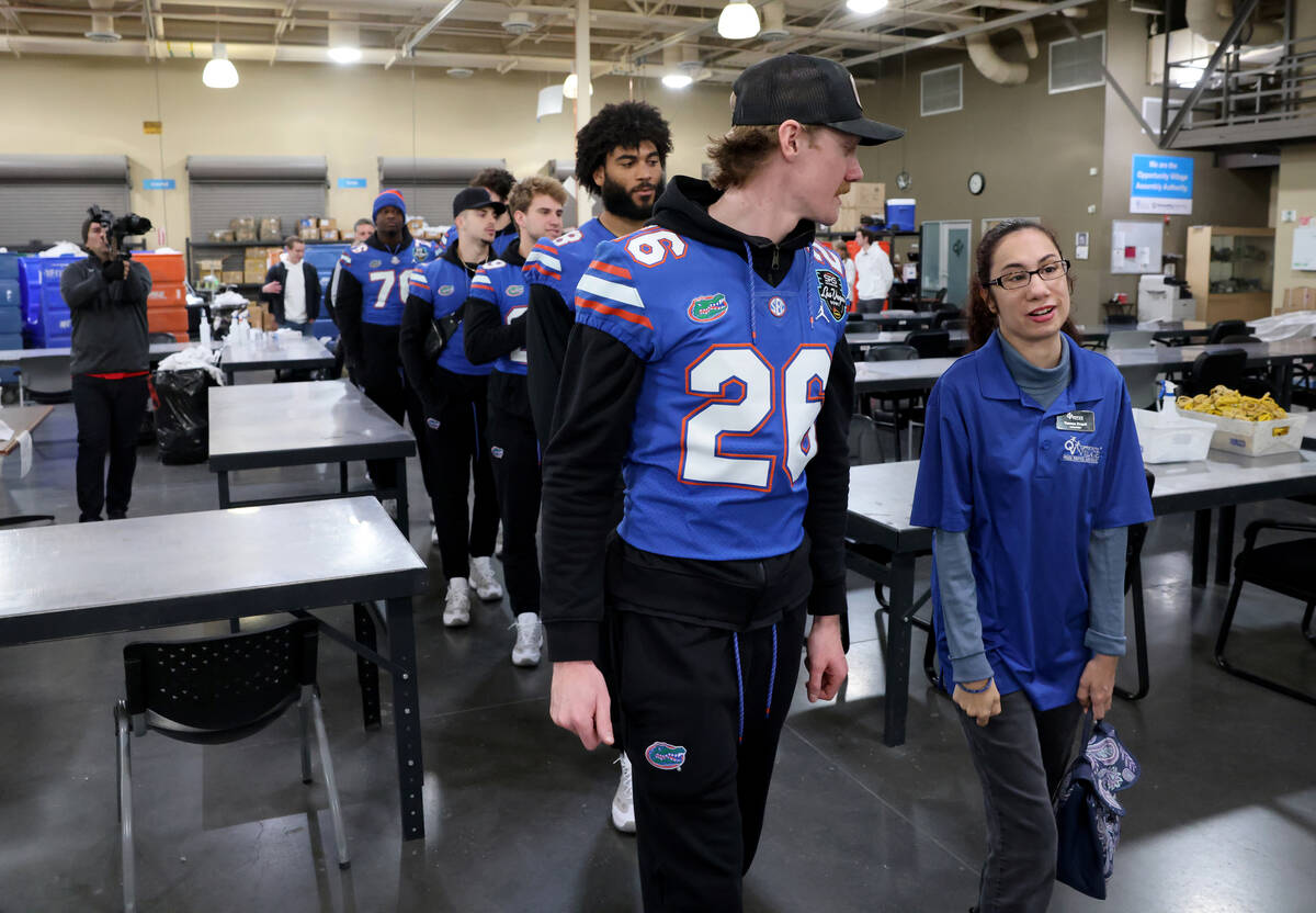Opportunity Village Ambassador Vanessa Stegall gives members of the University of Florida footb ...
