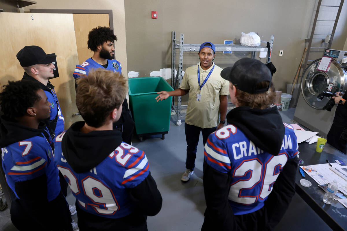 Opportunity Village custodian Roger Burns gives members of the University of Florida football p ...