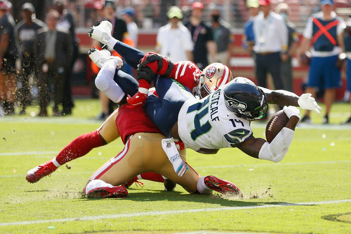Seattle Seahawks wide receiver DK Metcalf (14) dives into the end zone to score a touchdown aga ...
