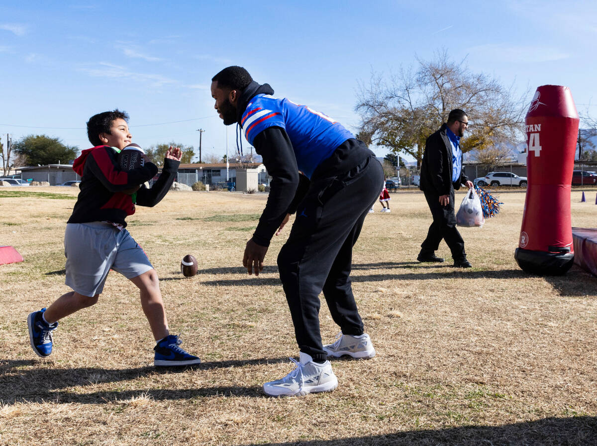 Florida Gators linebacker Amari Burney defends C.P. Squires Elementary School student Rudolf Na ...