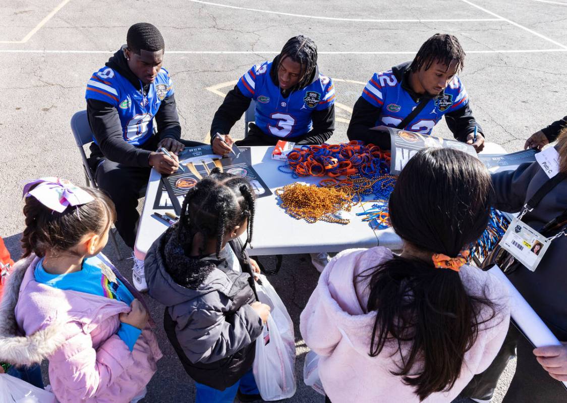 Florida Gators players Trey Dean III, Jason Marshall and Rashad Torrence II, right, sign autogr ...