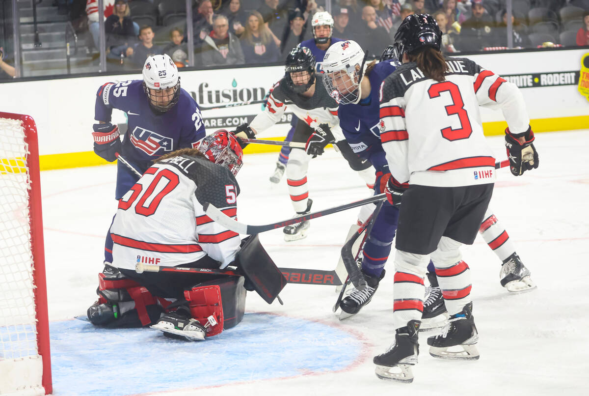 Canada goaltender Kristen Campbell (50) stops the puck against United States' Alex Carpenter (2 ...