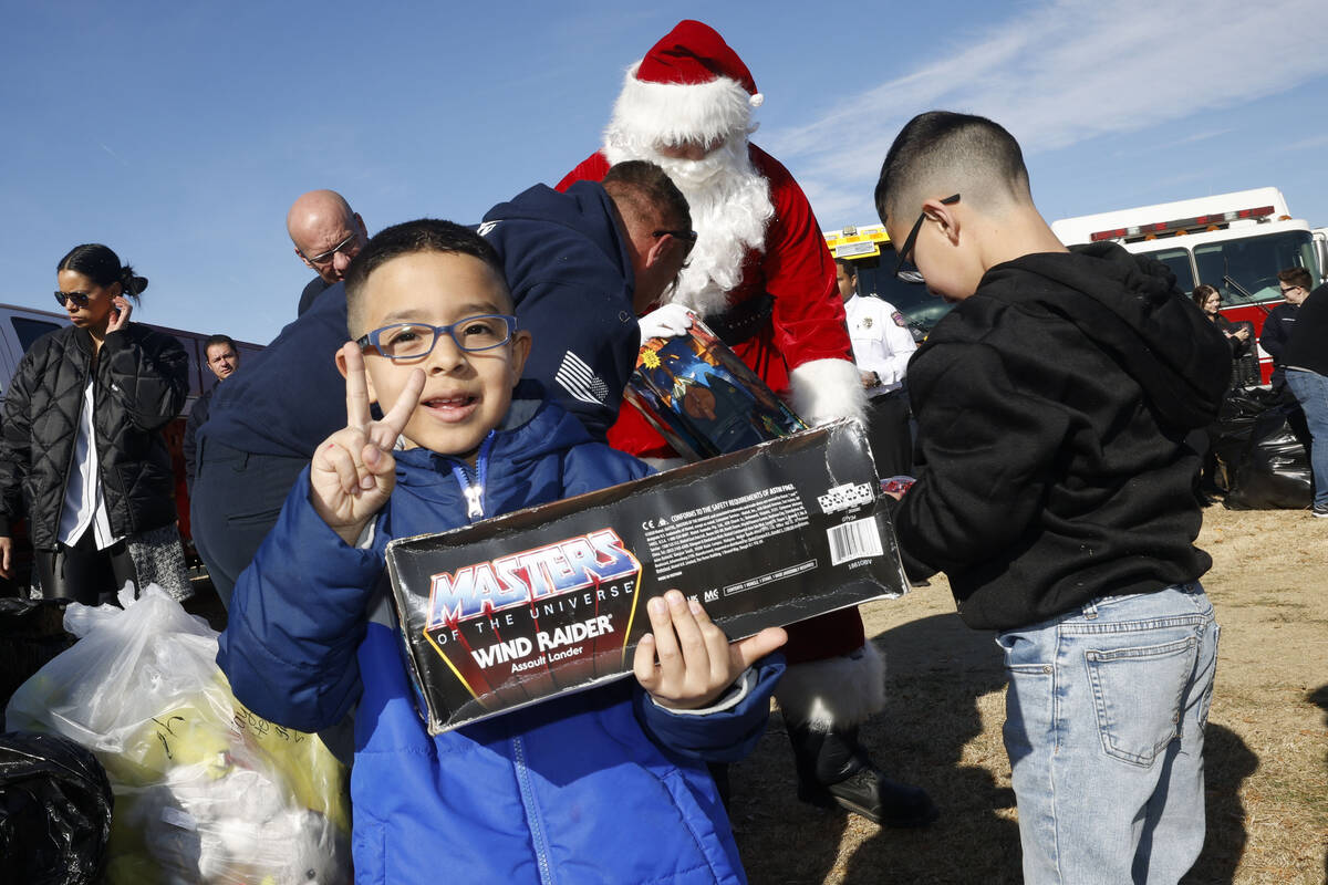 Fay Herron Elementary School first grader Josue Burgarin shows a V-sign after he received a toy ...