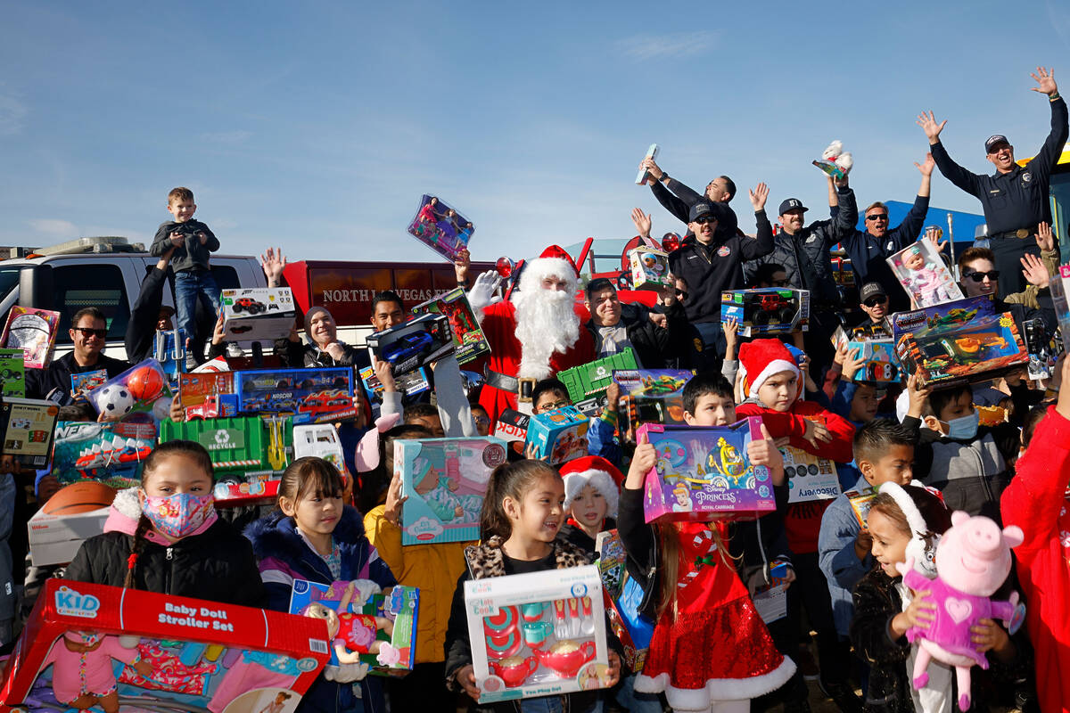 Herron Elementary School students show the toys that they just received while taking a photo wi ...