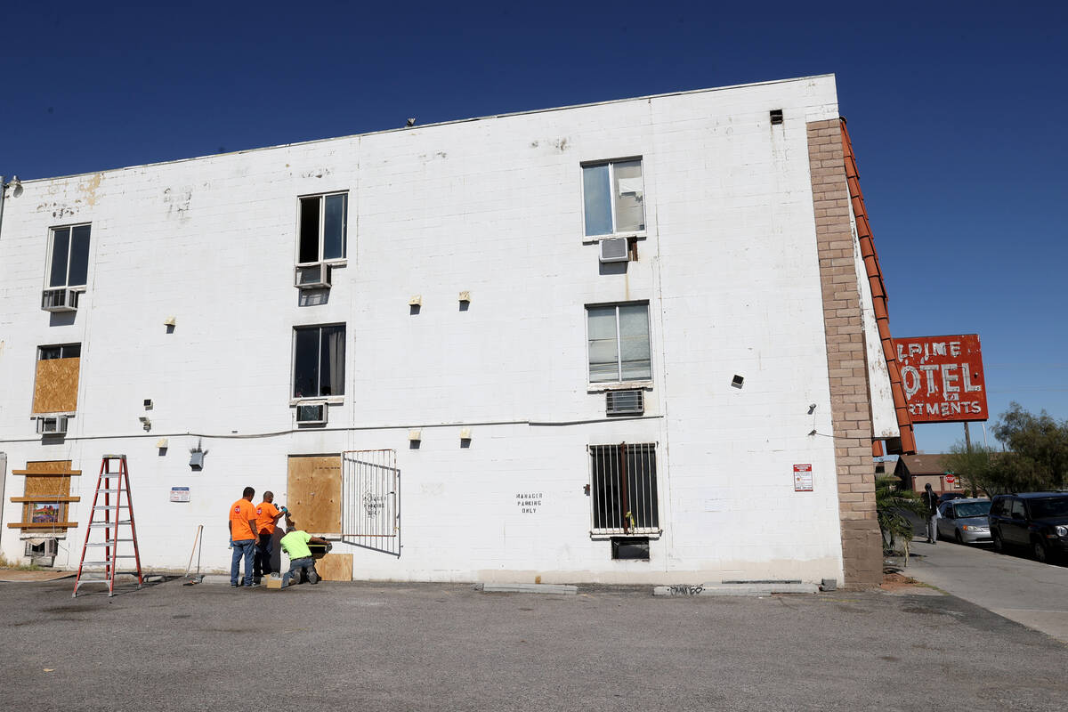 Workers board up windows at the Alpine Motel Apartments in downtown Las Vegas on Oct. 15, 2020. ...