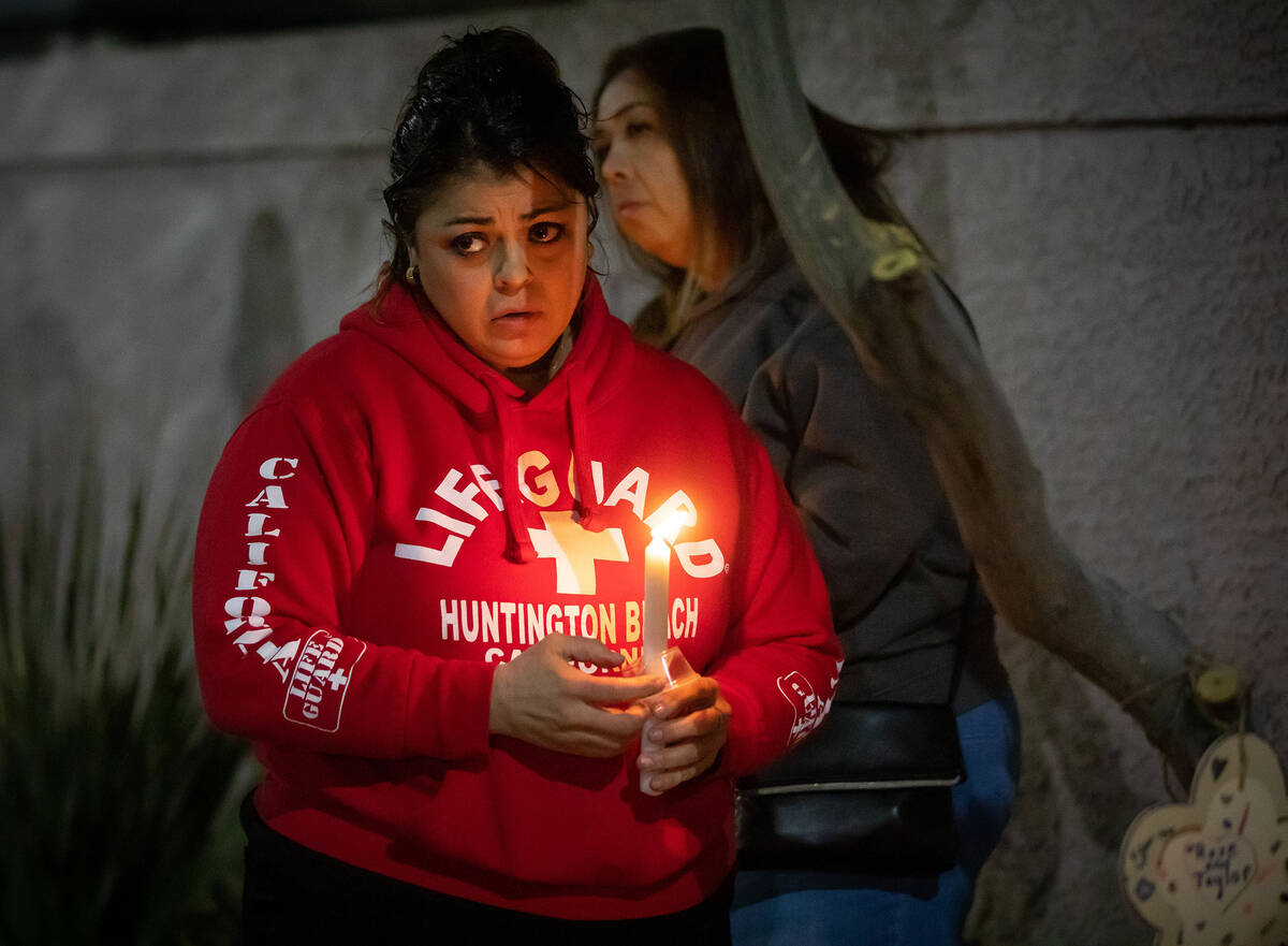 Monica Maldonado, front left, holds a candle during a candlelight vigil for Taeylr and Rose Wil ...
