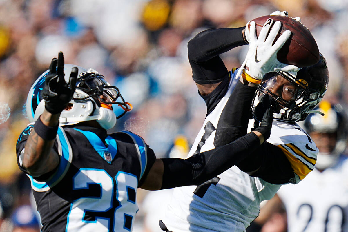 Pittsburgh Steelers wide receiver George Pickens catches a pass over Carolina Panthers cornerba ...