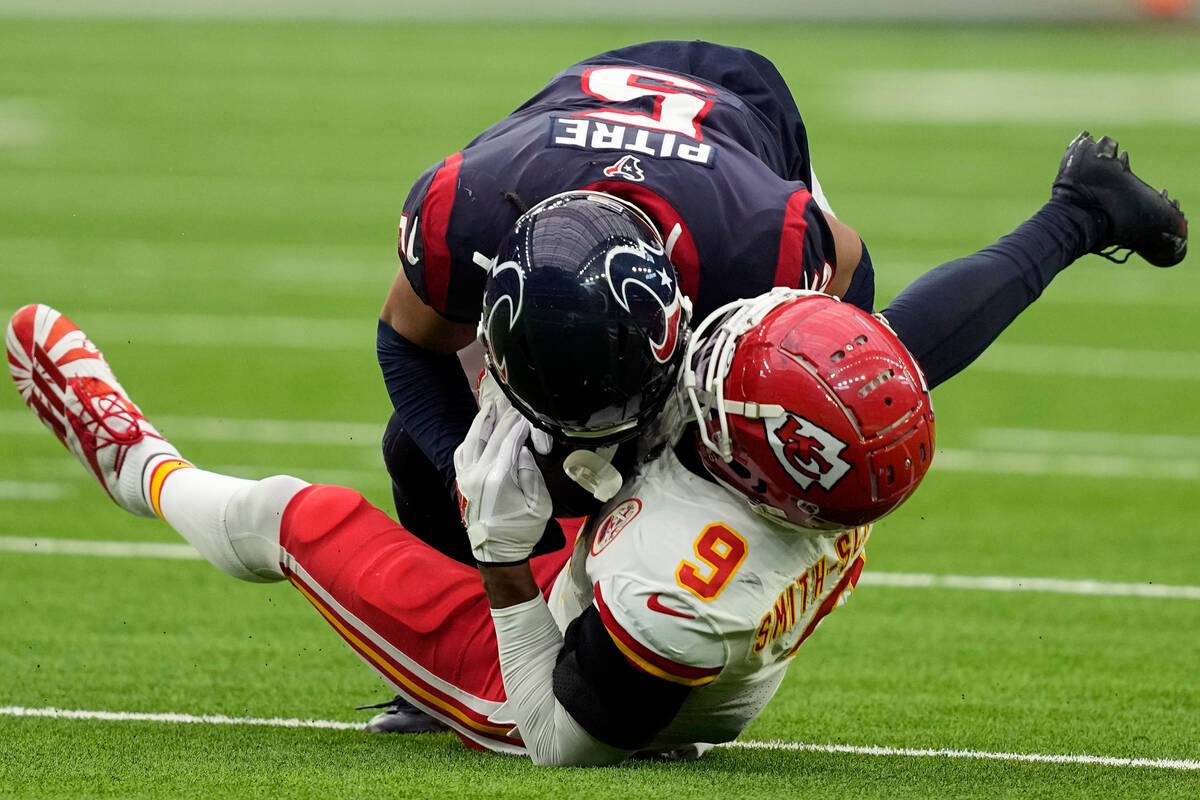 Kansas City Chiefs wide receiver JuJu Smith-Schuster (9) is hit by Houston Texans safety Jalen ...