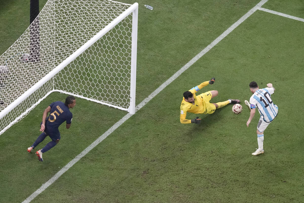 Argentina's Lionel Messi, right, scores his side's first goal passing France's goalkeeper Hugo ...