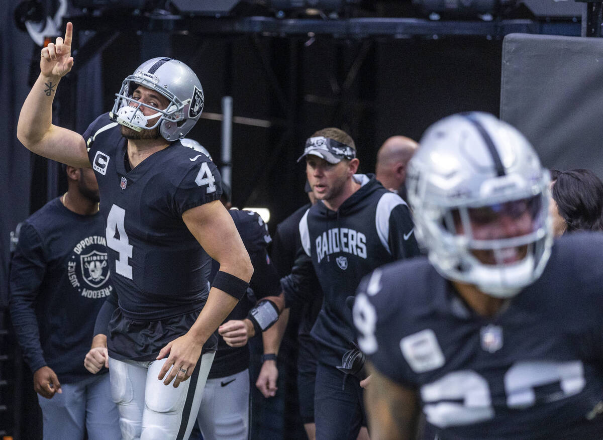 Raiders quarterback Derek Carr (4) points to the heavens while entering the field during warm u ...