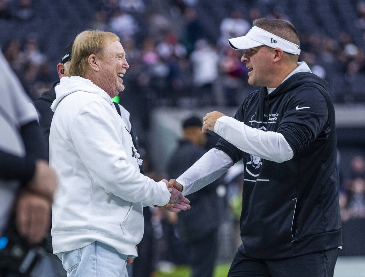 Raiders owner Mark Davis shakes hands with head coach Josh McDaniels during warm ups before the ...