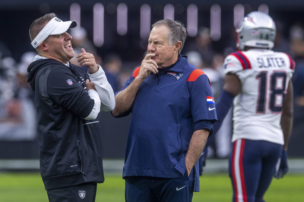 Raiders Head Coach Josh McDaniels talks with New England Patriots Head Coach Bill Belichick dur ...