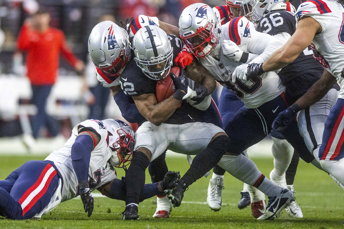 Raiders running back Ameer Abdullah (22) is turned back after a good return by New England Patr ...