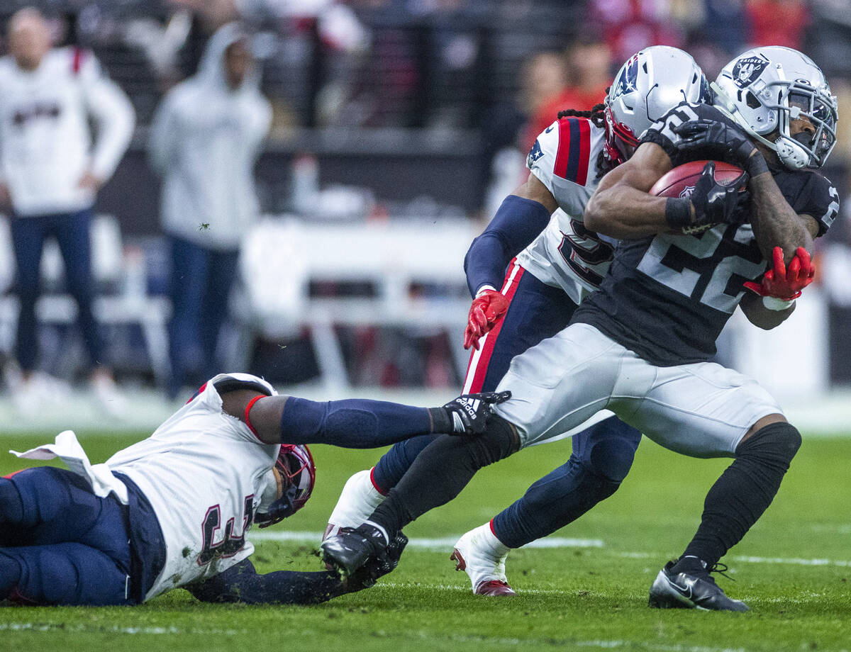 Raiders running back Ameer Abdullah (22) breaks a tackle attempt by New England Patriots safety ...