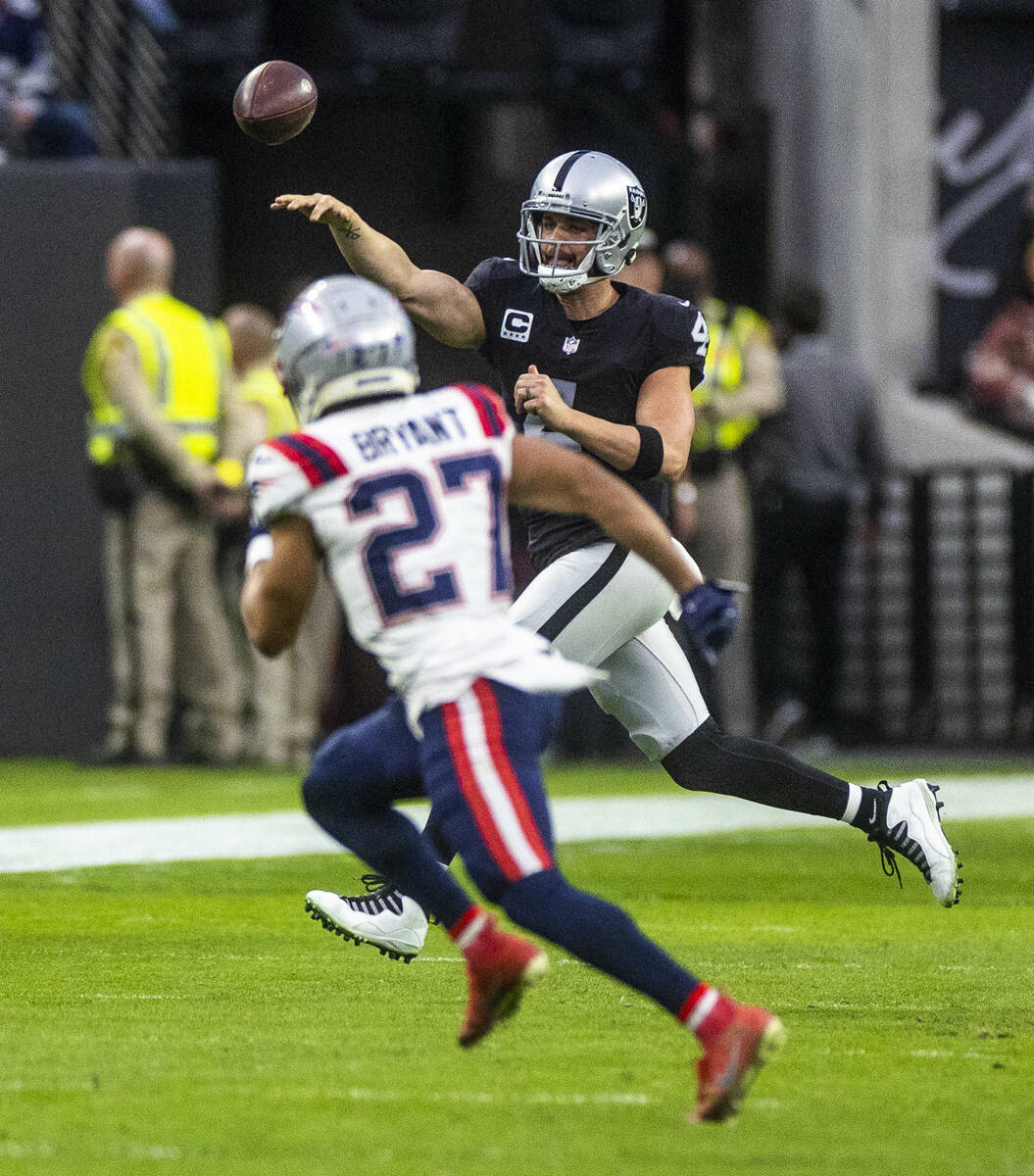 Raiders quarterback Derek Carr (4) gets off a pass over New England Patriots cornerback Myles B ...