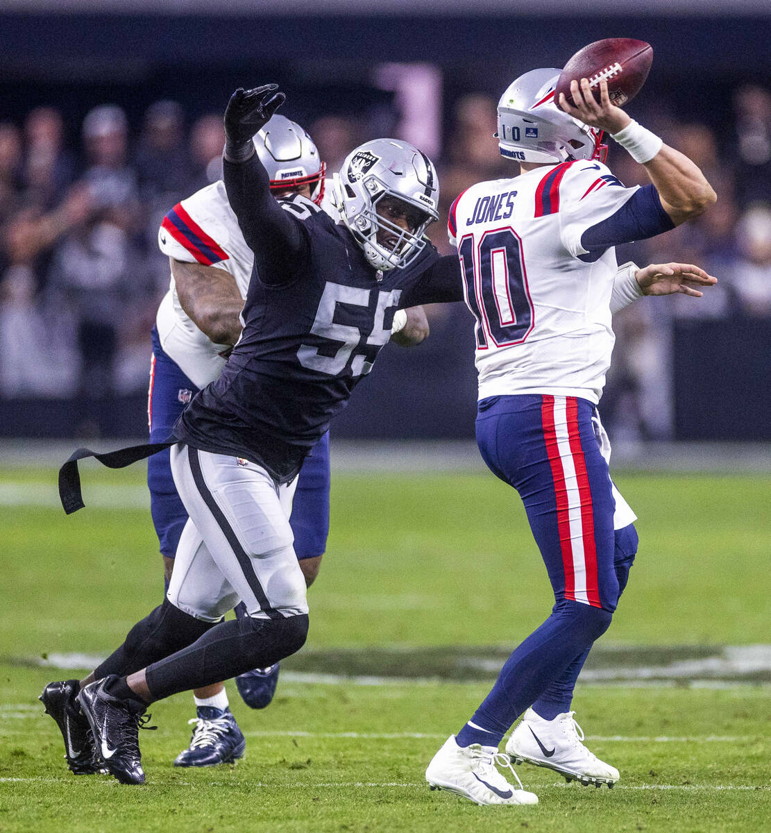 Raiders defensive end Chandler Jones (55) closes in on New England Patriots quarterback Mac Jon ...