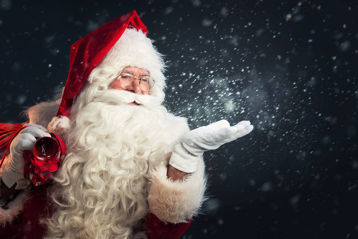 Santa Claus blowing magic snow off his hands.