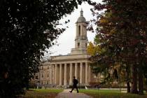 FILE- In this Nov. 9, 2017, file photo people walk by Old Main on the Penn State University mai ...