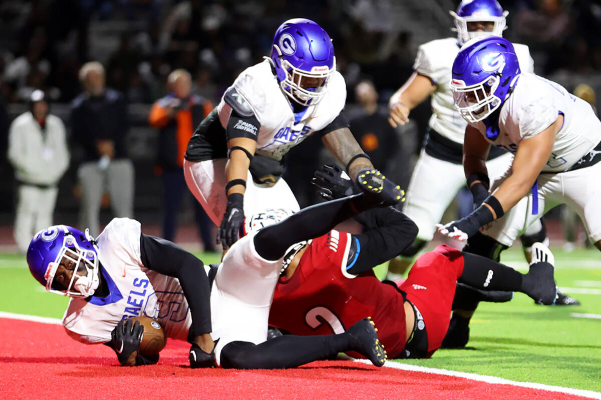 Bishop Gorman's Elija Lofton (9) dives for a touchdown as he gets tackled by Liberty's Andre Po ...