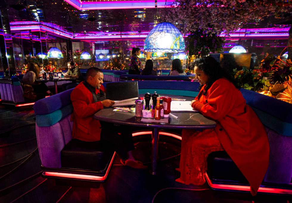 Abiy Megenta, left, and Beza Toelessa look through the menu at Peppermill on Tuesday, Dec. 13, ...