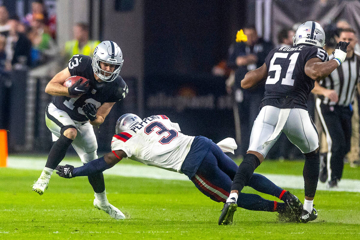 Raiders wide receiver Hunter Renfrow (13) looks to break a tackle attempt by New England Patrio ...