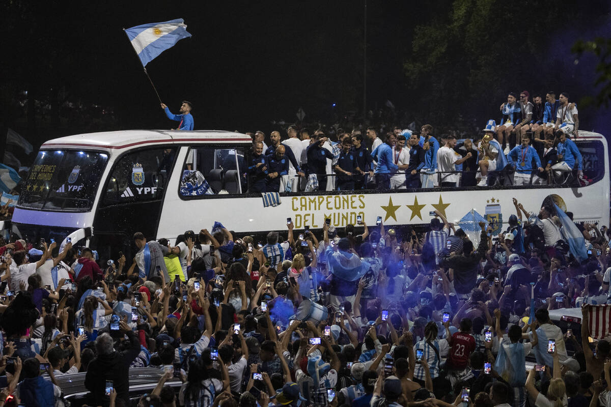 Soccer fans surround the bus taking Argentine soccer team that won the World Cup to the Argenti ...