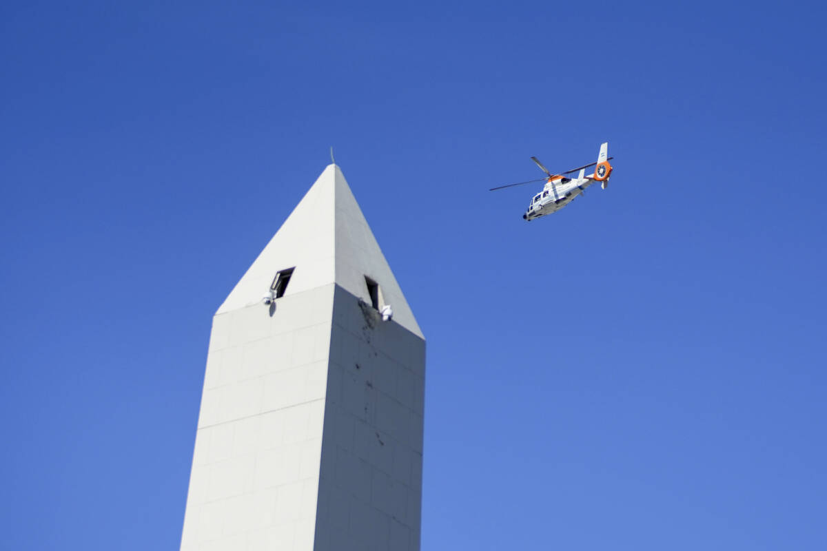 A helicopter flies over the Obelisk where people gathered in hopes of seeing the Argentine nati ...
