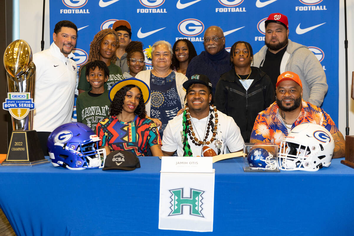 Jamih Otis, center, committed to the University of Hawai'i, poses for a photo with his family d ...