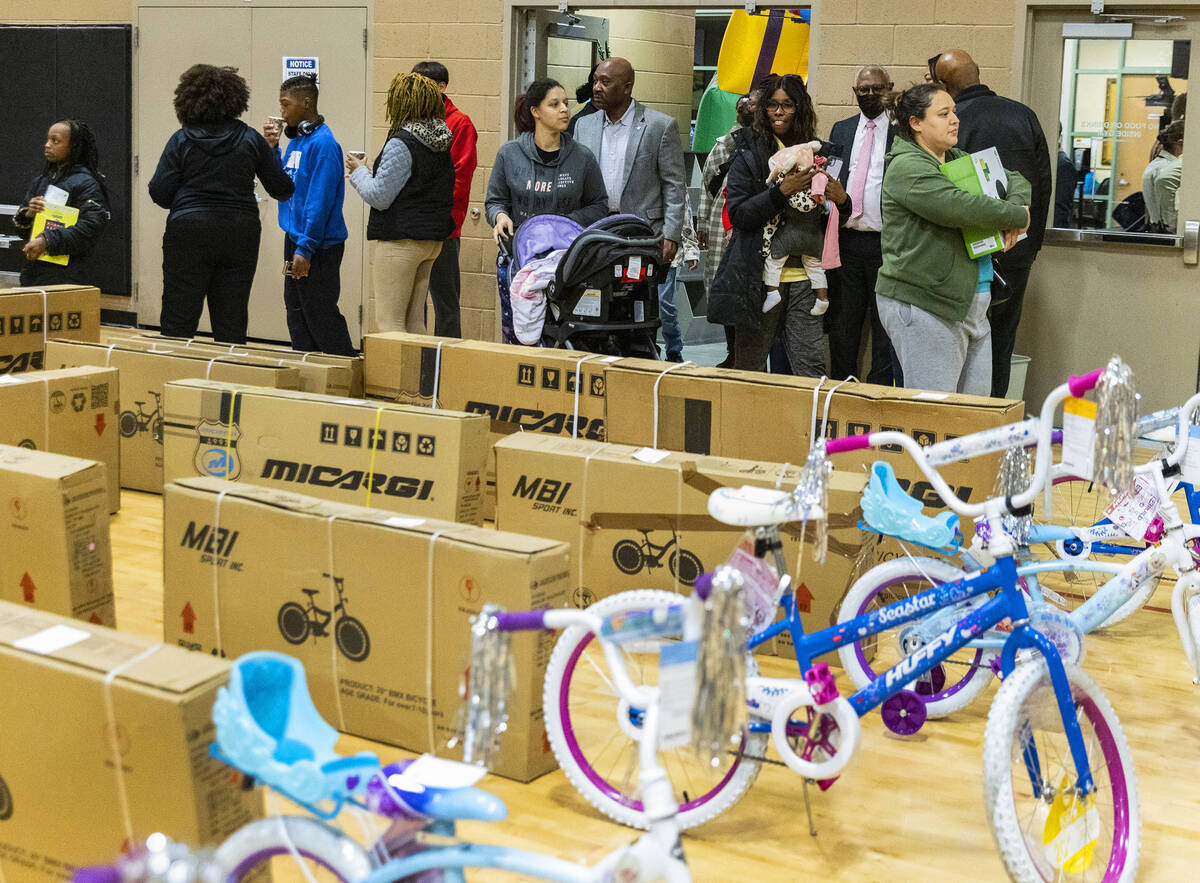 Children and their parents arrive to receive toys and bikes at Pearson Community Center, on Wed ...