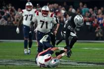 Las Vegas Raiders defensive end Chandler Jones (55) stiff arms New England Patriots quarterback ...